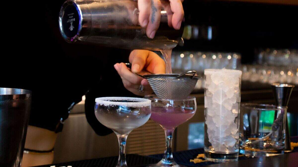 A bartender pours a drink at the bar. Starting in July, more than 20 restaurants, bars and lounges will participate in an affordable drinks program.