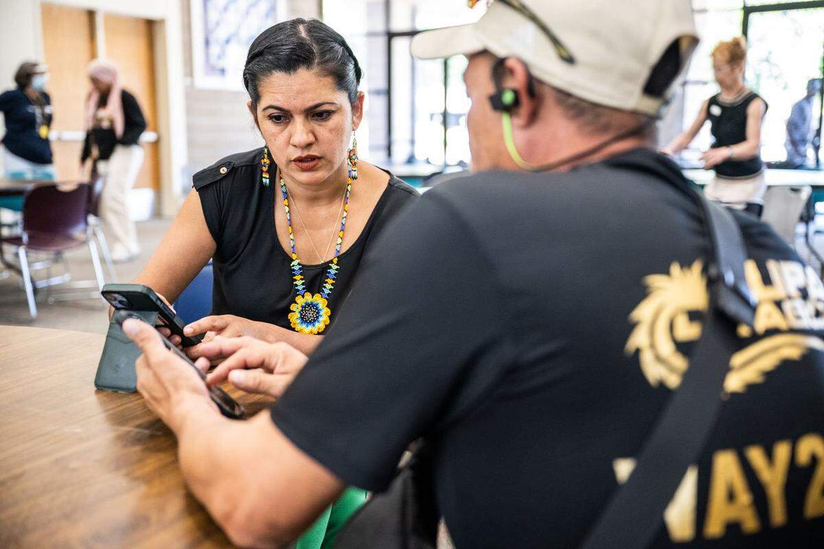Gabby Trejo, executive director of ACT speaks with Diego de Jesús Delgado Meléndez on June 29 during a day of activities in a local church. He is one of the migrants flown to Sacramento in early June.