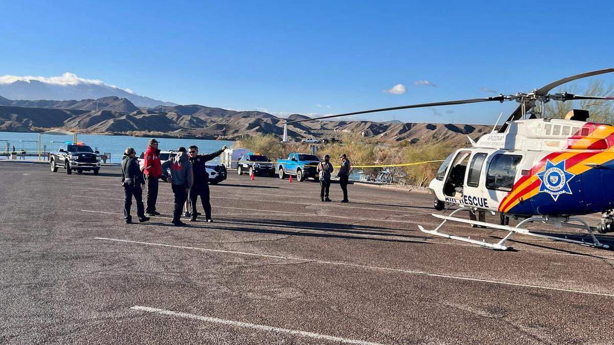 Searchers rescued one man and found a second dead after two kayaks flipped on Lake Havasu in Arizona.
