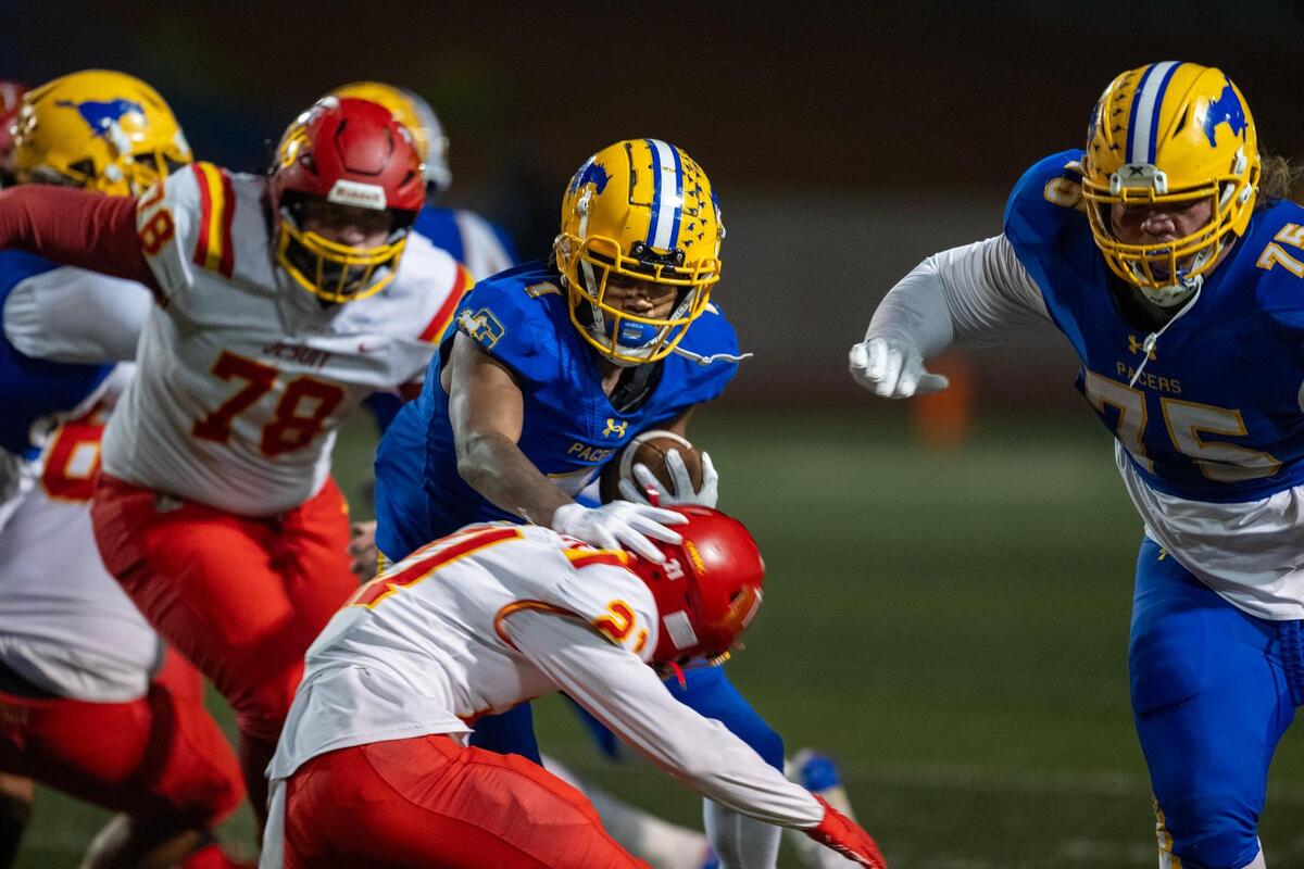 Grant Pacers running back Brandon Lambert (1) evades Jesuit Marauders defensive back Alex Dewar (21) in the first half of a Sac-Joaquin Section Division II quarterfinal playoff game on Friday, Nov. 15, 2024 in Del Paso Heights.