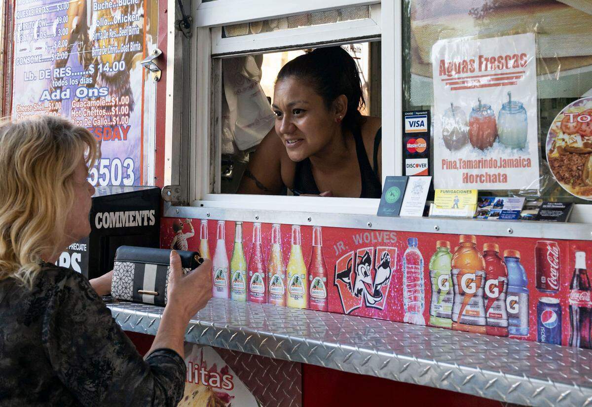 Clarissa Estrada, whose owns the Antojitos Jaimito Mexican-food truck with her husband, serves a first-time visitor last month in Woodland.