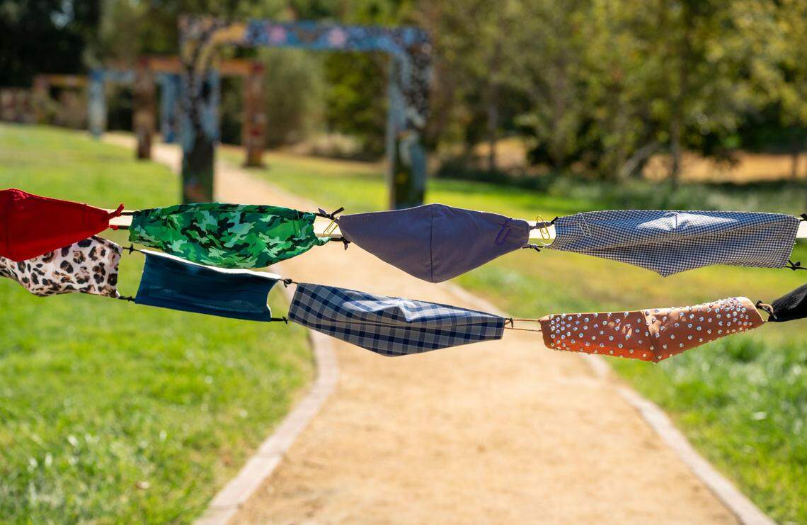 Face masks stitched together are tied to posts for the ribbon-cutting ceremony as the Davis Cemetery District dedicates a permanent COVID-19 Memorial on Sunday.