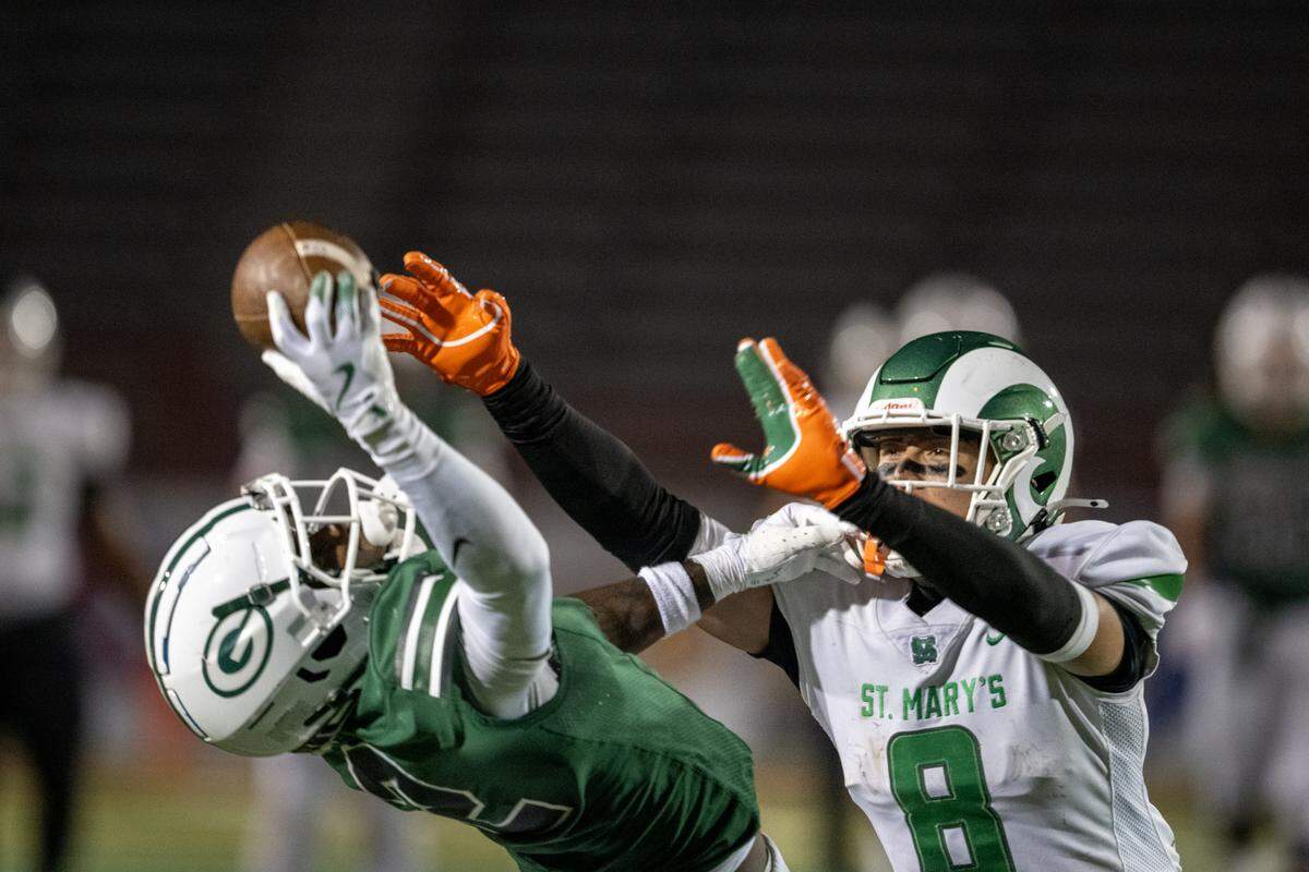 The Granite Bay Grizzlies' Darnell Turner (2) makes a one-handed catch in front of the St. Mary’s Rams' Moses Alexander (8) in the first half of the CIF Sac-Joaquin Section Division II football championship on Saturday at Hughes Stadium in Sacramento.