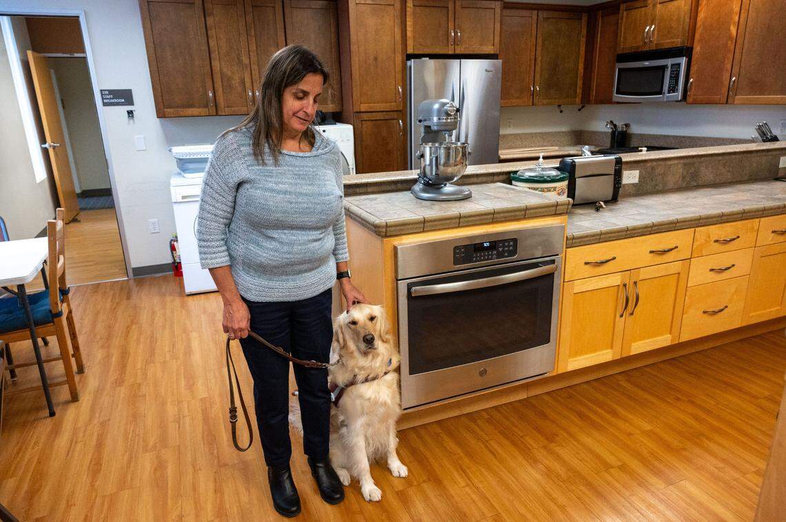 Jill Guilbeau, Braille instructor and manager of the braille transcription program at Society for the Blind, stands in the living skills instructional kitchen with her guide dog last month. The nonprofit is asking Book of Dreams for funds to upgrade some of their appliances.