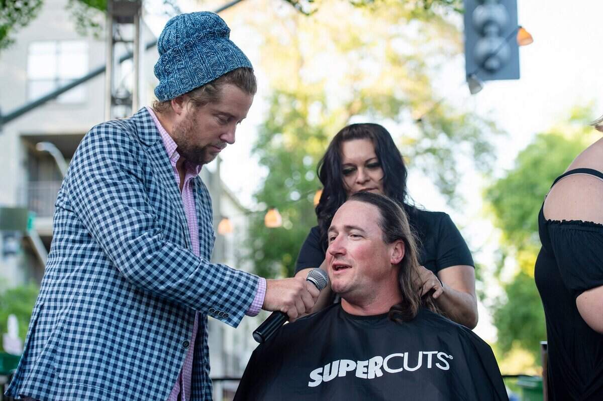 Peter Hoey, co-owner of Urban Roots, talks with Patrick Harbinson while he gets his head shaved by Gina Sayers, of Lodi Supercuts, during the St. Baldricks event at Mulvaney’s B&L in midtown Sacramento.