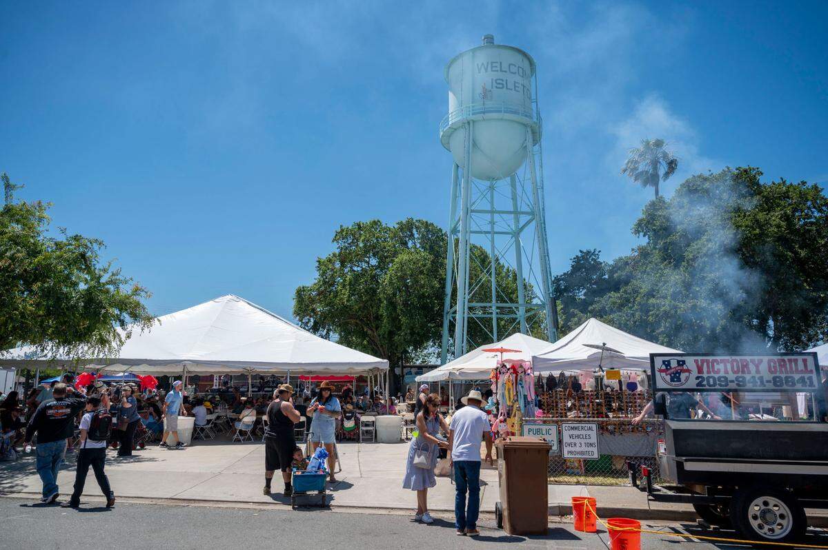People walk around at the City of Isleton Crawdad Festival on Sunday.