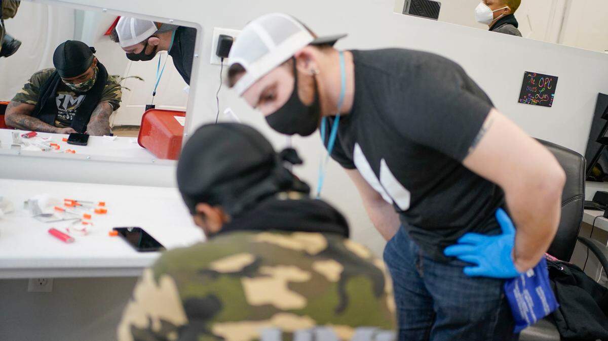 A staff member helps a drug user at a safe injection site in New York.