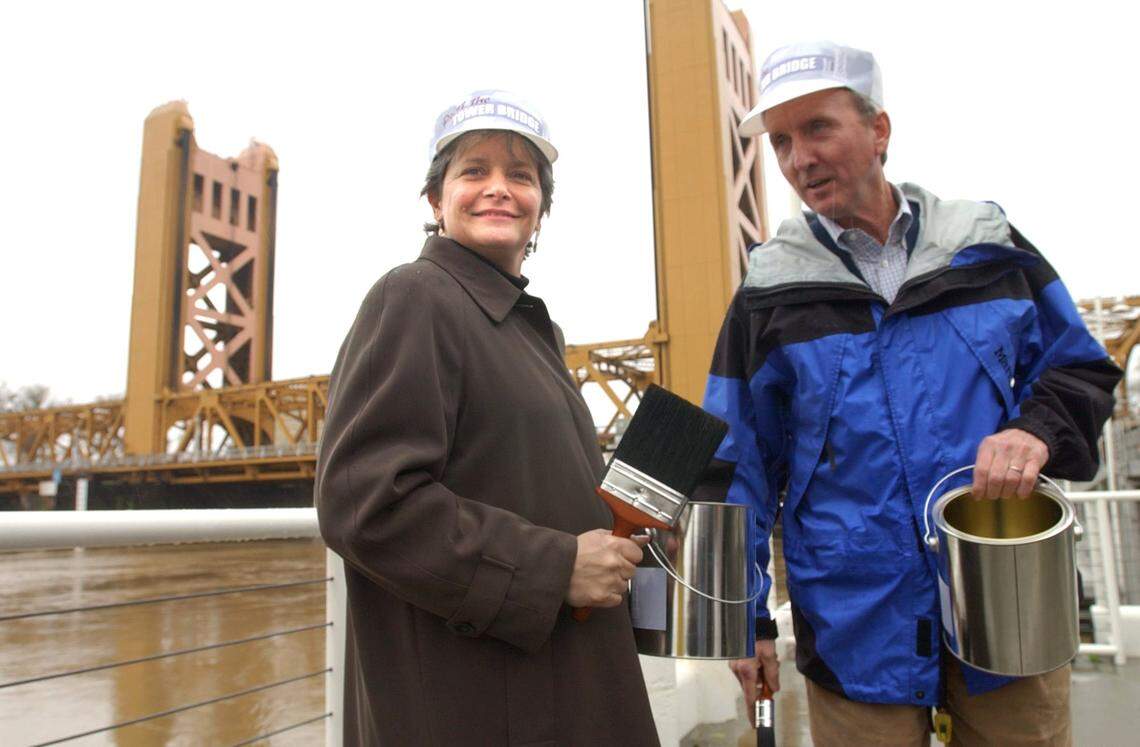 Then-Sacramento Mayor Heather Fargo, left, and City Councilman Ray Tretheway hold an empty cans of paint in front of the Tower Bridge in January 2002 as they help launch a “Paint the Tower Bridge” campaign. People could vote for three different colors. Metallic gold was the winner.