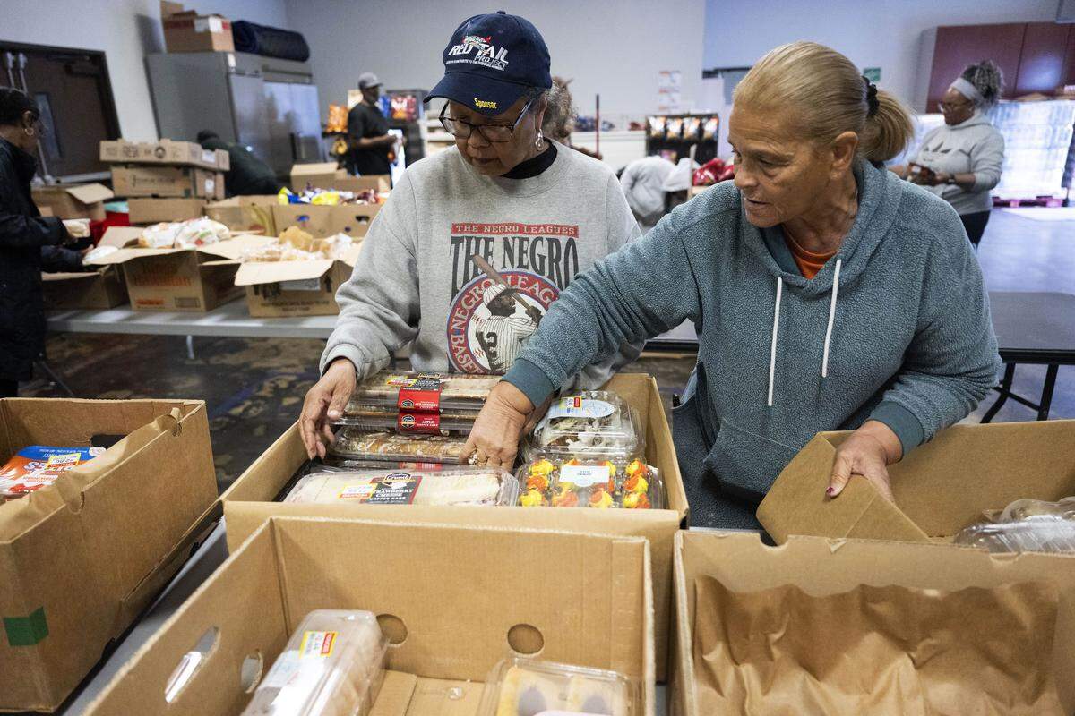 Bernice Evans, of Elk Grove, and Ethel Holloway-Boyd, of Citrus Heights, work with other volunteers as they sort food for Thanksgiving meals at the South Sacramento Christian Center on Nov. 20.