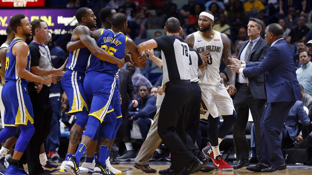 Golden State Warriors forward Kevin Durant and New Orleans Pelicans center DeMarcus Cousins (0) are restrained while going after each other during a scuffle in New Orleans, Monday, Dec. 4, 2017. Both players were ejected from the game.