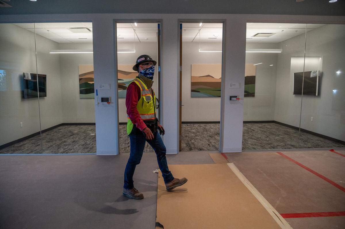 Erik Heerhartz, project director with the state Department of General Services, walks past the Cagle Lake and Lake Elsinore conference rooms on the third floor of the new Natural Resources Headquarters building on Thursday. The design team focused on the theme of California’s natural resources in the artwork and design of the conference room spaces.