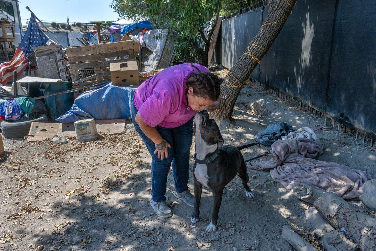 Tamitha Myler kisses her dog Rescue at Camp Resolution in August.