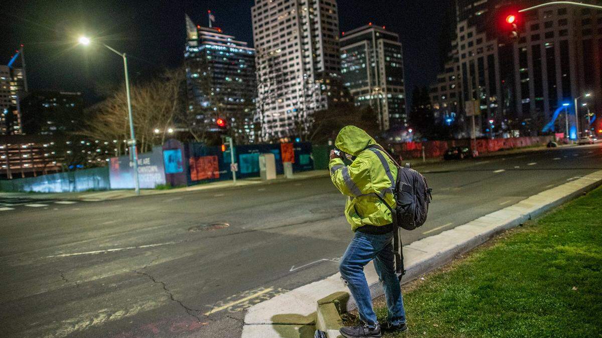An unhoused man who participated in the annual 2022 Homelessness Point-in-Time Count adjusts his head lamp while waiting to cross an intersection in downtown Sacramento on Wednesday, Feb. 23, 2022. He was headed to use a food voucher for Subway that he received from volunteers for participating. The U.S. Department of Housing and Urban Development requires that a PIT count be performed every two years in order to receive federal funding for homelessness programs.