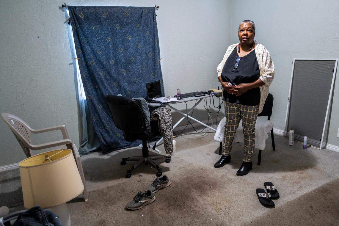 Lenora Jackson utiliza una tabla de planchar como escritorio a principios de este mes después de trasladar su verdadero escritorio y otras pertenencias al almacén mientras lucha por permanecer en su casa de renta en Oak Park. La habitación era su dormitorio hasta que las chinches infestaron su cama y tuvo que tirarla. Dice que las alfombras manchadas estaban allí cuando se mudó y necesitan ser reemplazadas.