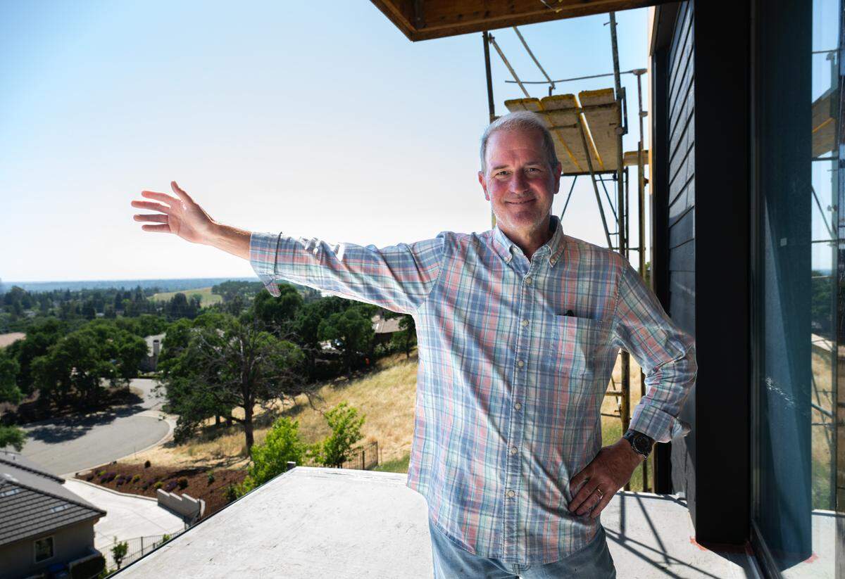 Folsom City Councilmember Mike Kozlowski gestures toward the expansive view of the Sacramento Valley from the upper-level deck at his unfinished home Friday.