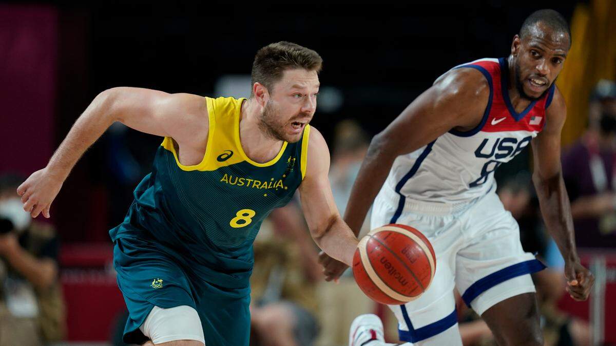 Australia’s Matthew Dellavedova (8) and United States’s Khris Middleton (8) chase the ball during men’s basketball semifinal game at the 2020 Summer Olympics, Thursday, Aug. 5, 2021, in Saitama, Japan. (AP Photo/Charlie Neibergall)