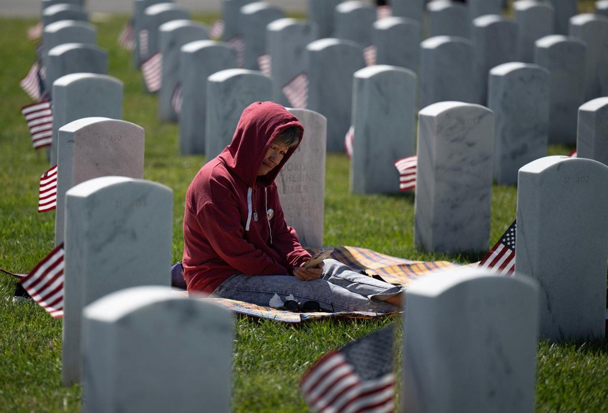 Liza Raymundo of Elk Grove weeps as she visits her husband Ray Raymundo’s grave site following the Sacramento Valley National Cemetery Memorial Day Ceremony on Saturday, May 25, 2024, in Dixon. 