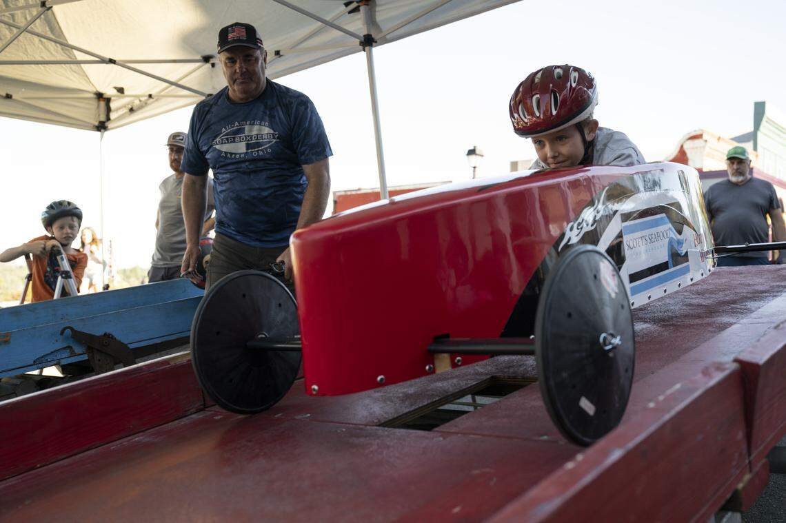 David Stagnaro, left, the race director for Northern California Soap Box Derby, releases a lever to send Ben Bakker, 8, of Rancho Cordova, down the incline in his stock car during the Folsom Historic District’s All-American Soap Box Derby in Folsom on Sunday, Oct. 5, 2025.