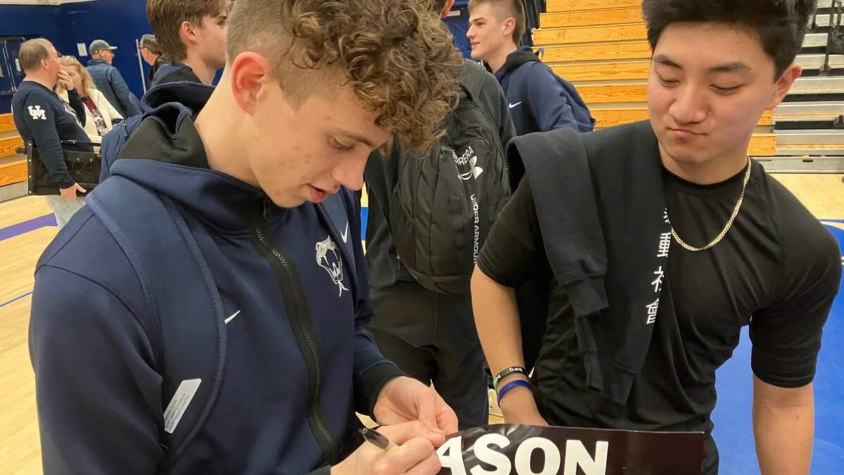 Union Mine High School senior guard Mason Mottashed signs a poster promoting his 1,000th career point.