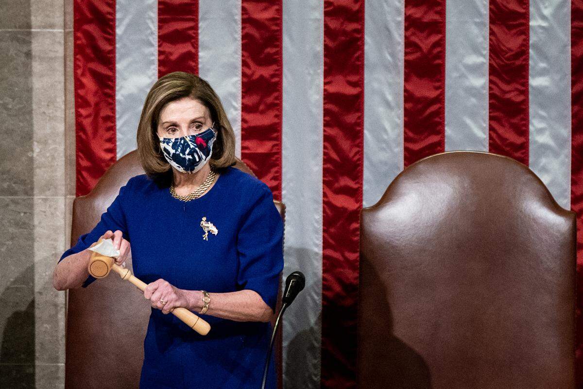House Speaker Nancy Pelosi sanitizes the gavel after Vice President Mike Pence walked off the dais during a joint session of Congress to certify the 2020 Electoral College results on Jan. 6, 2021, in Washington, D.C. A group of Republican senators said they would reject the Electoral College votes of several states unless Congress appointed a commission to audit the election results.