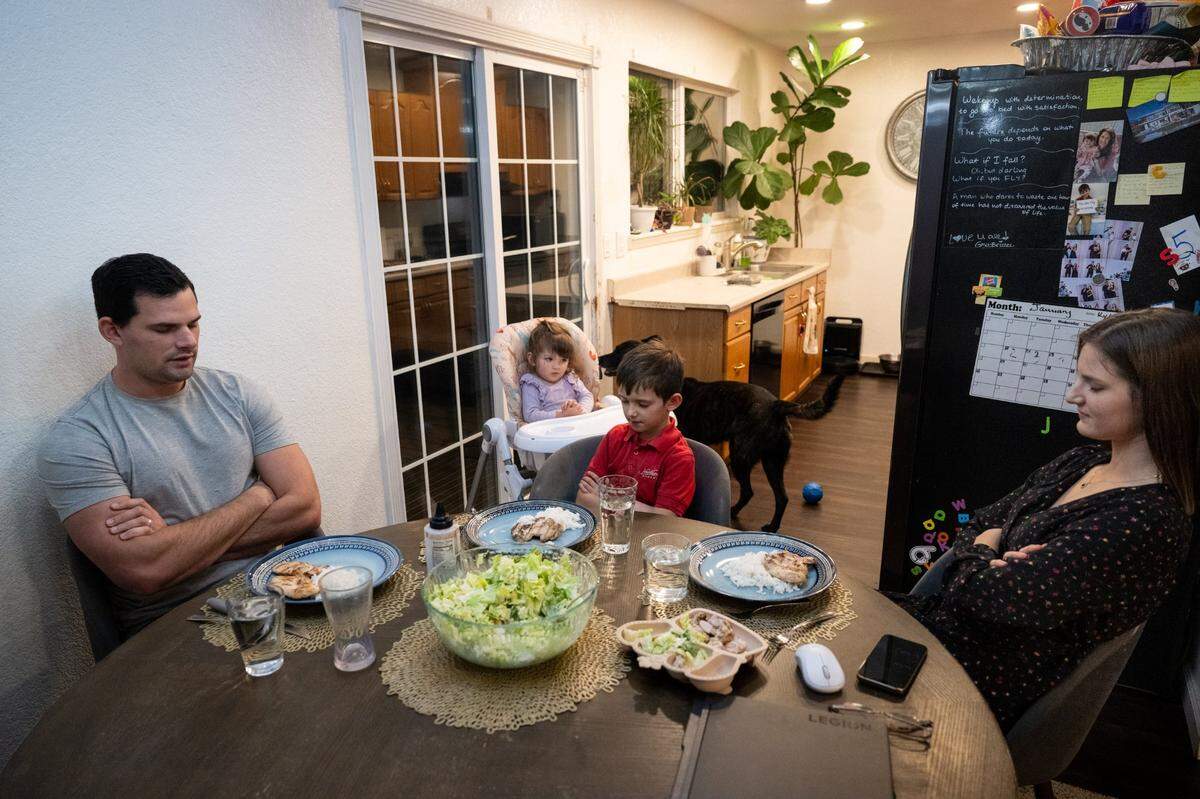 Anna Curry and her husband Issak pray before eating dinner with their children, Lotus, 1½, and Kylan, 6, on Monday in Rancho Cordova. The couple has a 2.25% mortgage rate on their 1,067-square foot property, and has decided to stay in the too-small home rather than give up the favorable rate.