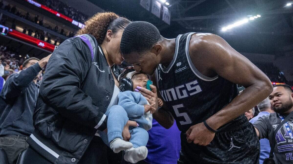Sacramento Kings guard De’Aaron Fox (5) kisses his son Reign, held by his mother Recee Caldwell, after winning Game 2 of the first-round NBA playoff series at Golden 1 Center on Monday, April 17, 2023.