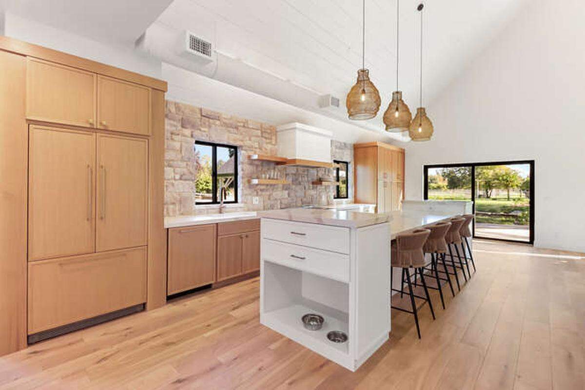 The kitchen is part of the open concept living space and adds stone accents and other natural elements to the interior of the home.