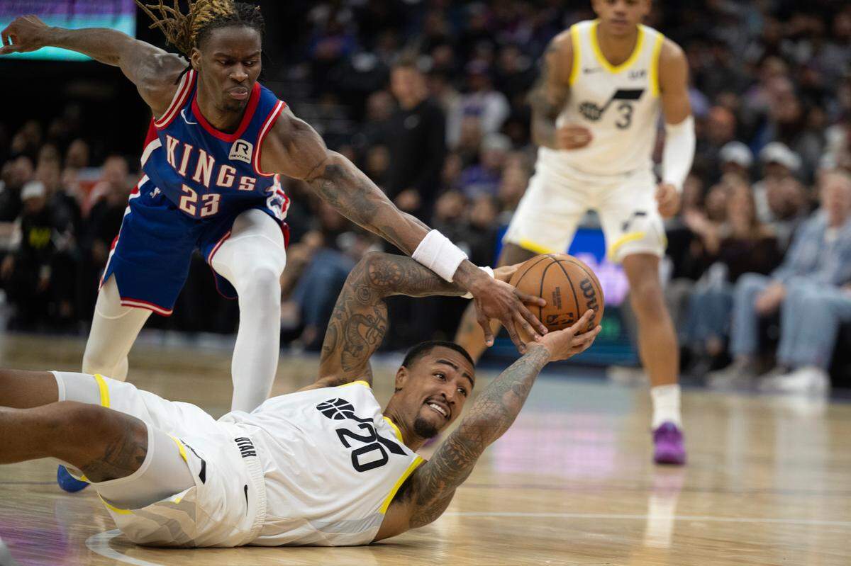 Sacramento Kings guard Keon Ellis (23) slaps the ball away from Utah Jazz forward John Collins (20) in the first half of an NBA game on Saturday at Golden 1 Center.