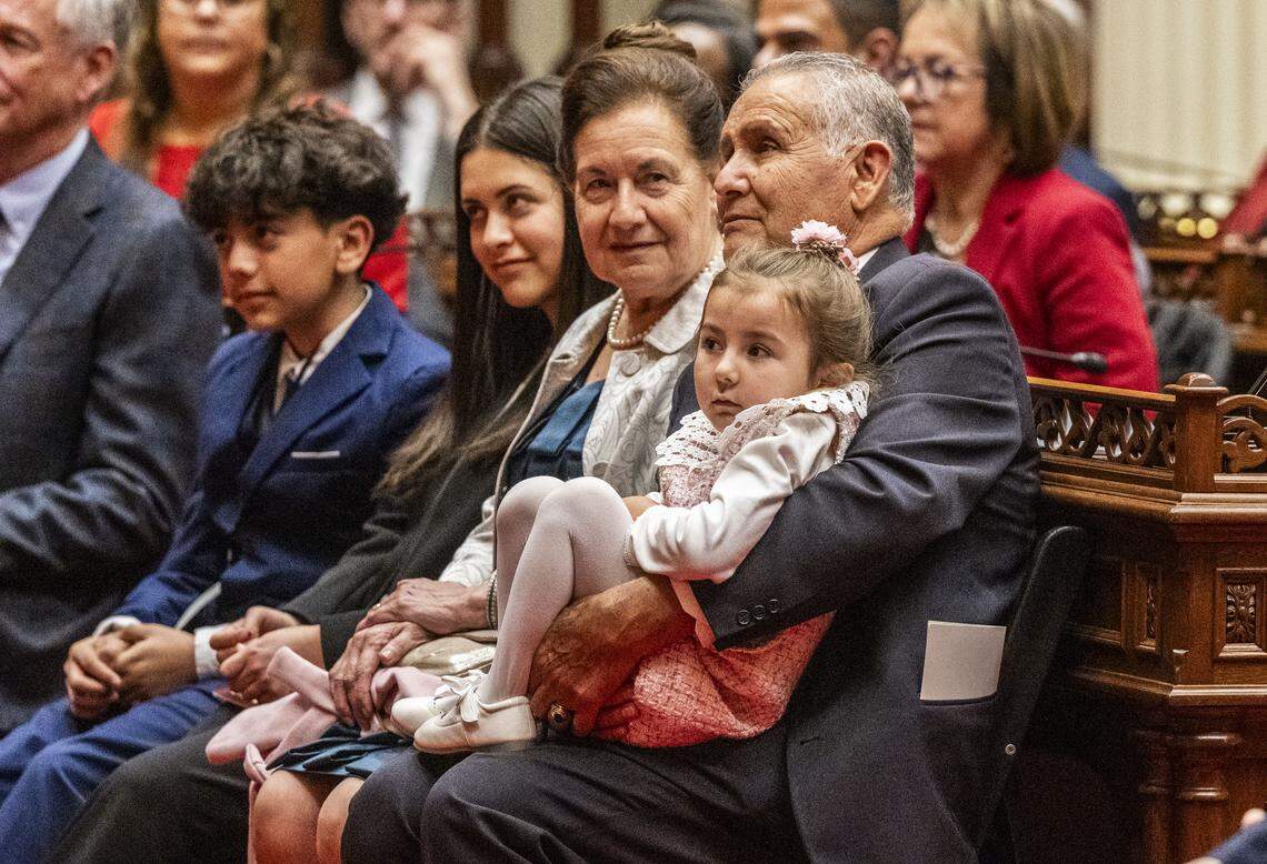 Jesús Limón, padre de la presidenta pro tempore del Senado, Monique Limón, demócrata de Goleta, sostiene en brazos a su nieta de cinco años, Gianna, mientras él y su esposa Oralia escuchan el discurso de su hija durante la ceremonia de juramentación el lunes 5 de enero de 2026.