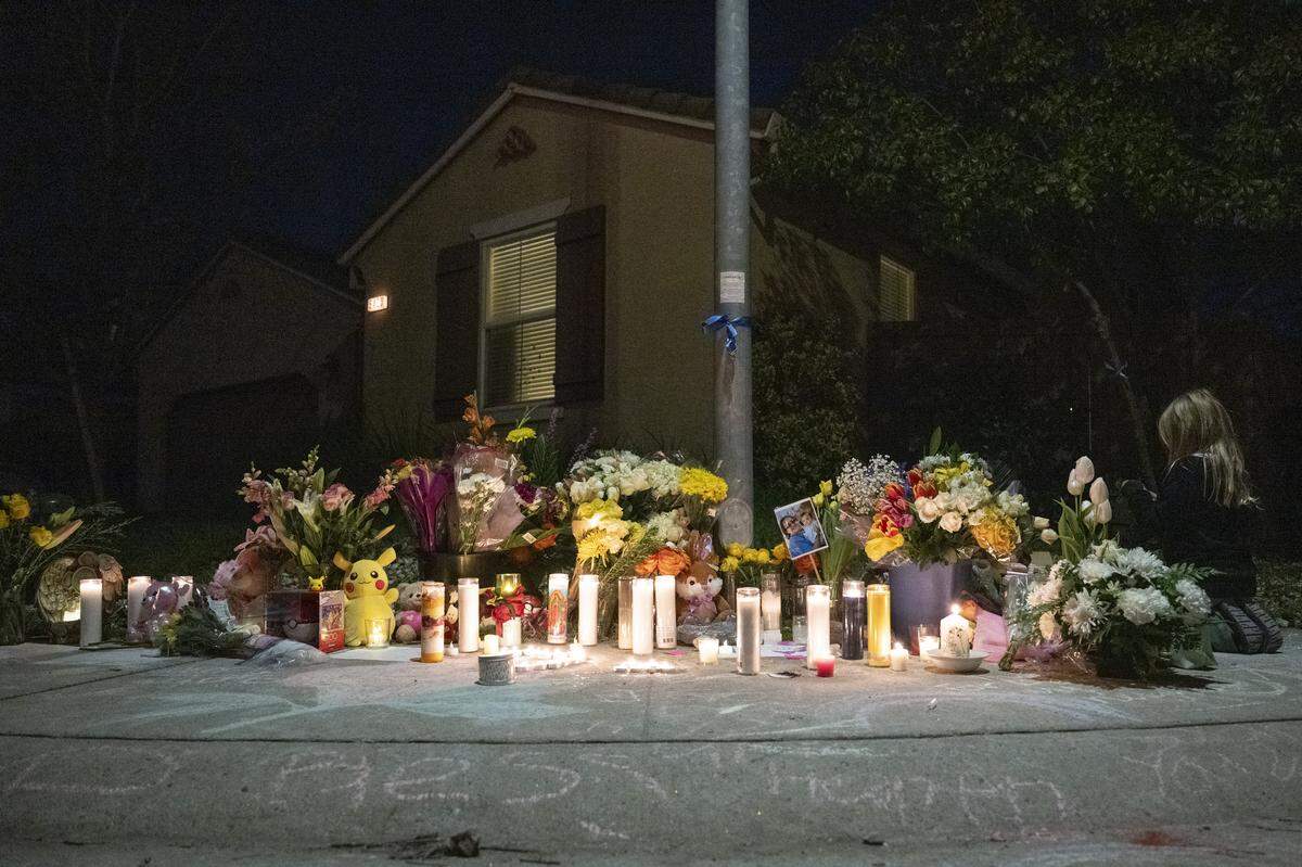 Neighbors light candles outside the home of the Vallerga family during a vigil on Mill Water Circle in Rancho Cordova on Sunday to remember the family who were found dead inside on Jan. 27 in an apparent murder-suicide.