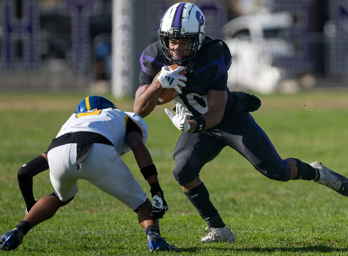 The Sacramento Dragons’ Darrius Moore (10) attempts to evade the Del Campo Cougars’ Isaiah Richmond (8) for a short gain in a Sac-Joaquin Section first-round playoff game on Nov. 9. 