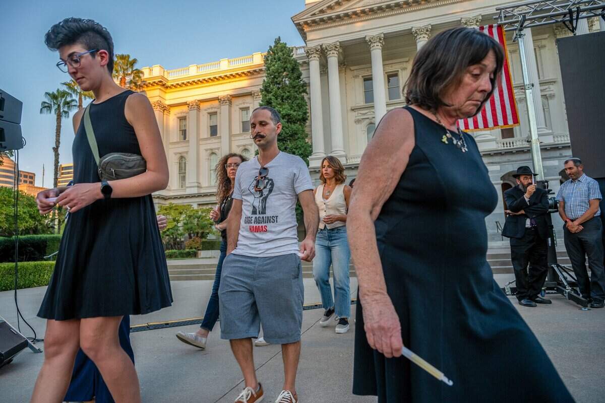Ryan Pessah, center, leaves the stage on Monday after he lit a candle for his cousin Yair Yaakow during a candlelight vigil at the state Capitol in Sacramento to mark the one-year anniversary of the Hamas attack on Israel. Yaakow died after he was taken hostage by Hamas.