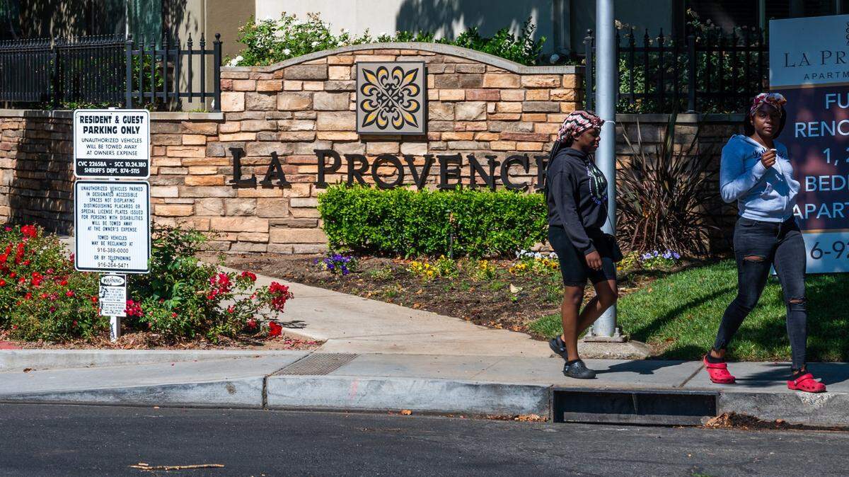 People walk out of La Provence apartment complex in East Sacramento on June 30, 2021.