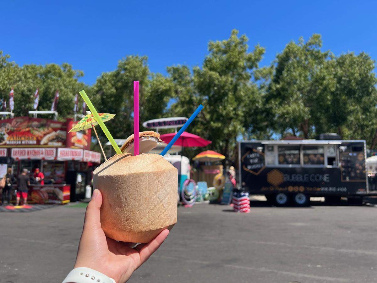Sac Bee reporter holds a coconut from Machete-fresh Coconuts on the State Fair’s opening day.