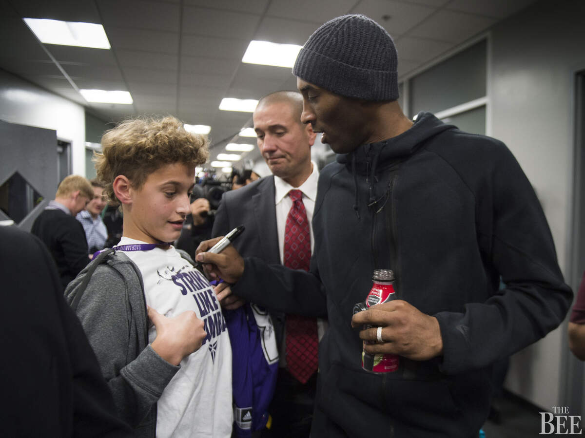 Los Angeles Lakers forward Kobe Bryant (24) signs autographs after his team’s 118-115 loss to the Sacramento Kings.