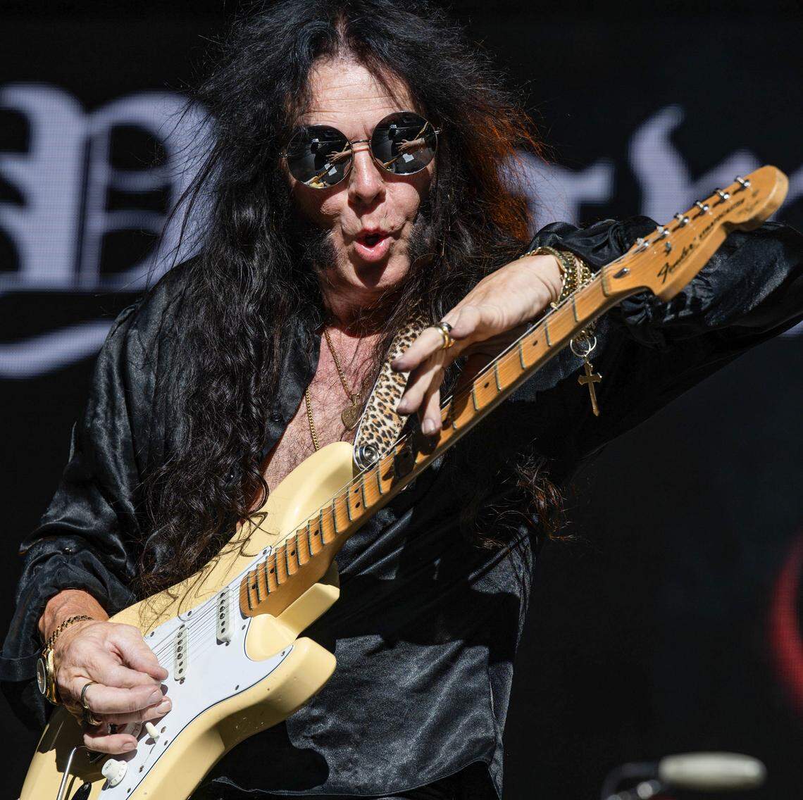 The fingers of Swedish-American heavy metal guitarist Yngwie Malmsteen are reflected in his sunglasses as he performs during the Aftershock festival on Friday, Oct. 3, 2025, in Discovery Park in Sacramento.  