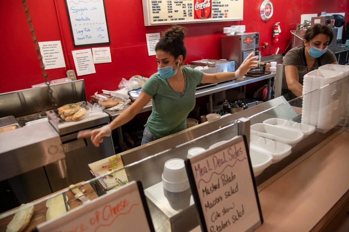 Marian Ziyadeh, left, and Nada Ziyadeh, right, members of the family that has owned Bud’s Buffet since 1988, rush to fill orders for customers who packed the restaurant Thursday, Sept. 17, 2020, in downtown Sacramento, after hearing it will be closing its doors Friday due to the coronavirus pandemic.
