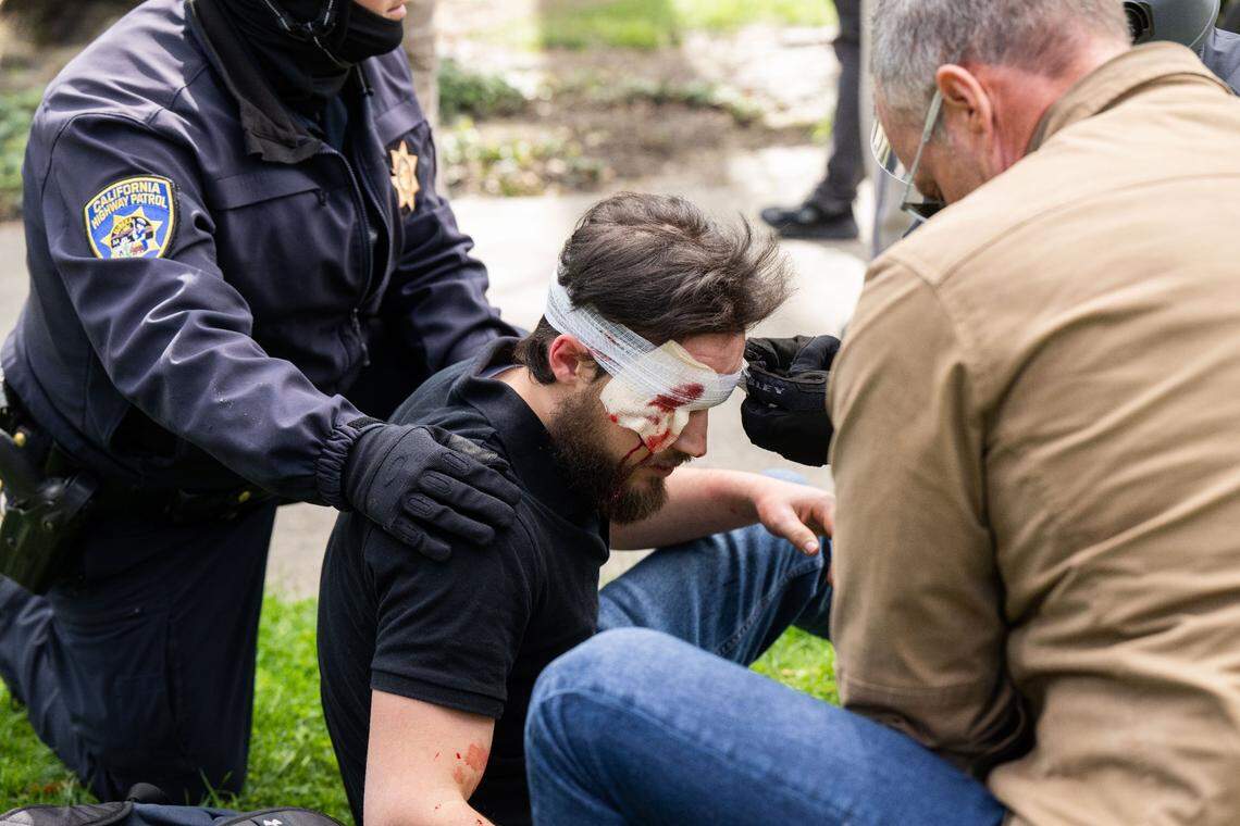 An unidentified man is tended to by state Capitol CHP officers on Friday after he was injured by a member of the Pride Was A Riot trans activist march, which was protesting the Detransition Awareness Day event at the state Capitol.