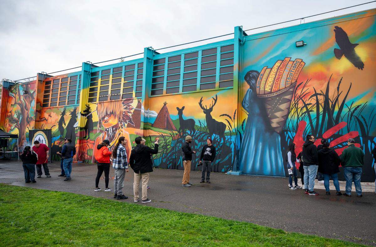 Members of the community look at a 30’ tall and 100’ wide mural during an unveiling ceremony Saturday at Miwok Middle School, formerly Sutter Middle School, depicting scenes and elements of Miwok life.