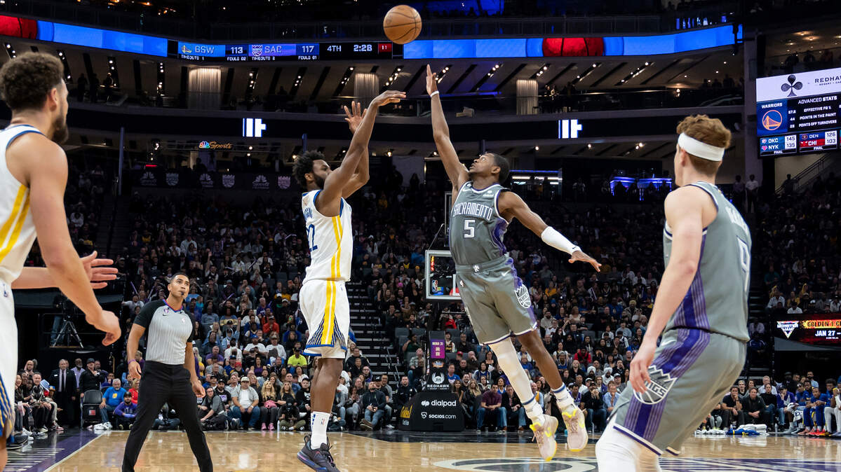 Golden State Warriors forward Andrew Wiggins (22) attempts the 3-pointer over Sacramento Kings guard De’Aaron Fox (5) during the fourth quarter in the NBA basketball game Sunday, Nov. 13, 2022, at Golden 1 Center in Sacramento. Fox had 22 points and eight assists. The Kings won 122-115.