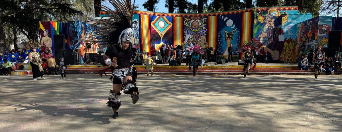 Dressed as an Aztec warrior, Edi Santana performs a dance ritual to open the Cesar Chavez celebration at Sacramento’s Southside Park on Saturday.