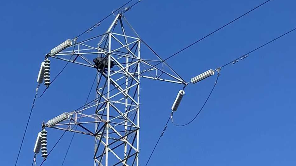 A person is seen atop a power transmission line at Mack Road and Highway 99 in south Sacramento on Monday, Aug. 29, 2022.