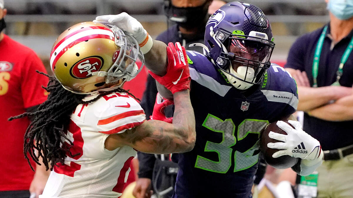 Seattle running back Chris Carson stiffarms San Francisco cornerback Jason Verrett on Sunday.
