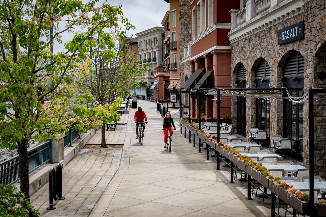 People ride bikes along an empty riverfront in downtown Napa on Saturday. Napa County saw a 74 percent reduction in average distance traveled according to a study of smartphone data.
