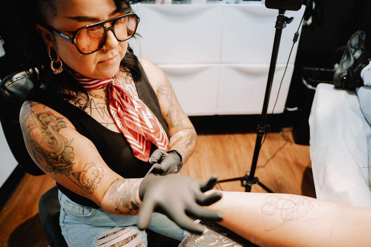 Maricelia Dominguez tattoos a client at her shop, Les Tattoos, in Rio Linda. Dominguez is born and raised in south Sacramento and has been tattooing for 9 years.