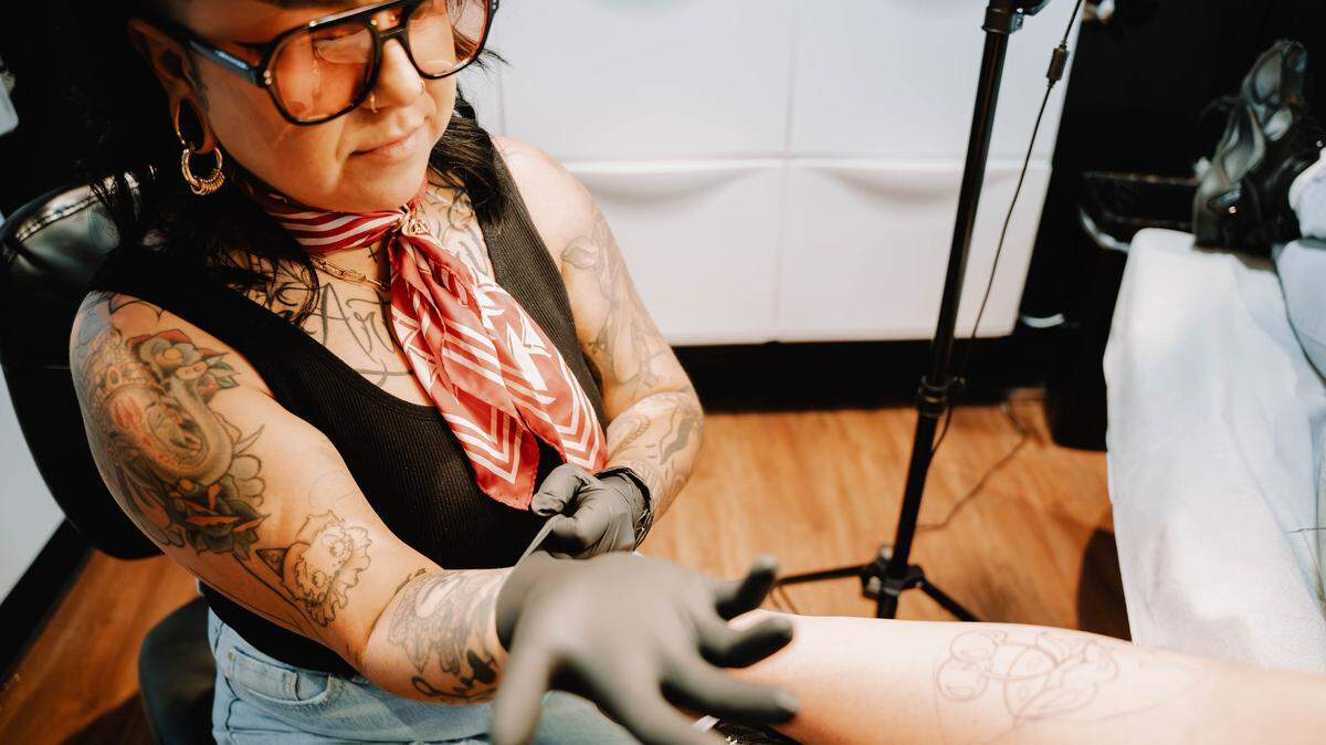 Maricelia Dominguez tattoos a client at her shop, Les Tattoos, in Sacramento. Dominguez is born and raised in south Sacramento and has been tattooing for nine years.