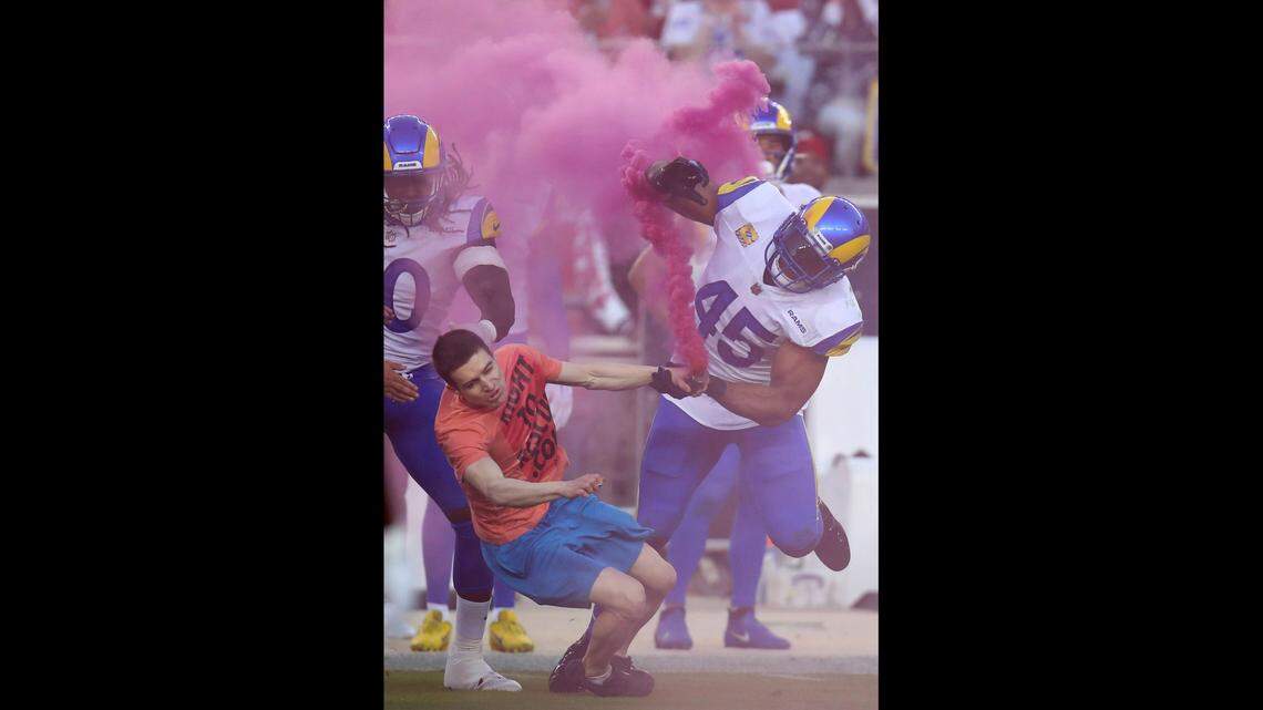 Los Angeles Rams linebacker Bobby Wagner, right, tackles an animal rights protester who ran onto the field during a game against the San Francisco 49ers on Monday, Oct. 3.