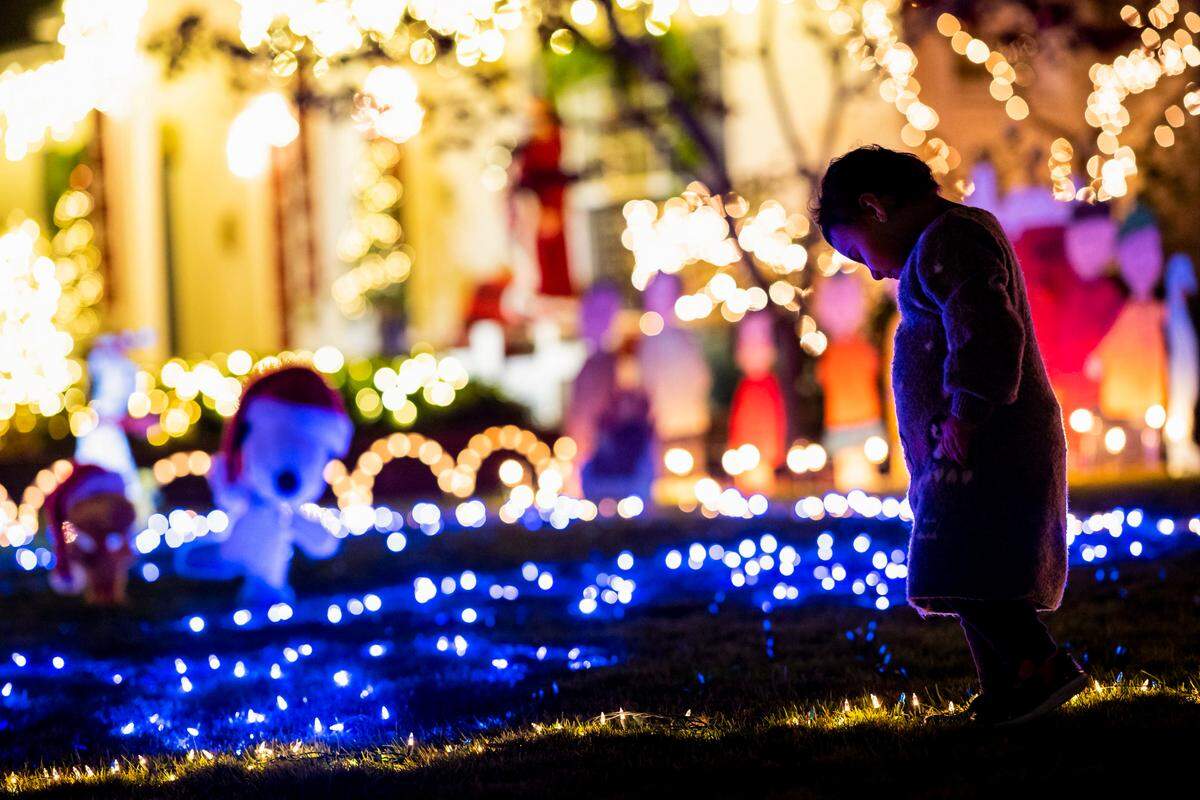 Aisha Barati, 2, of Sacramento, beams as she walks along the “ice rink” that’s part of the Peanuts-themed holiday lights display Wednesday, Dec. 9, 2020, at 1418 42nd Street in East Sacramento’s Fabulous 40s.