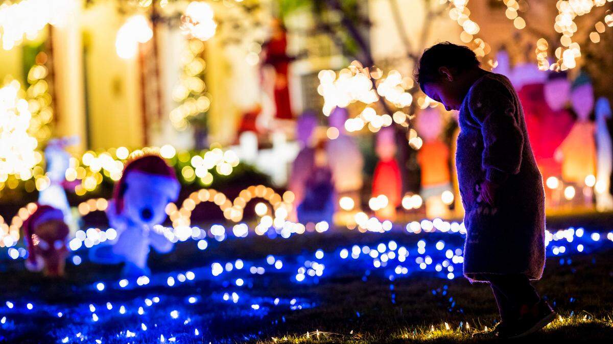 Aisha Barati, 2, of Sacramento, beams as she walks along the “ice rink” that’s part of the Peanuts-themed holiday lights display Wednesday, Dec. 9, 2020, at 1418 42nd Street in East Sacramento’s Fabulous 40s.