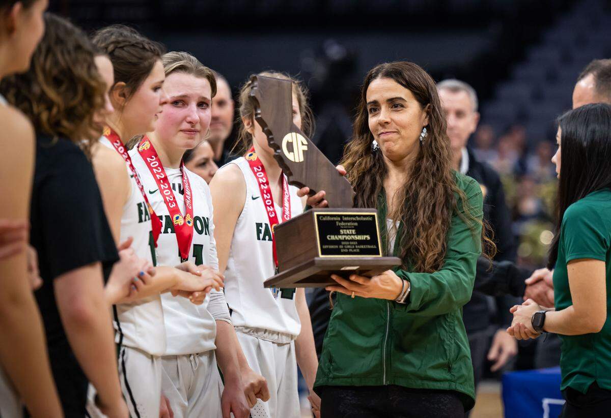 Colfax Falcons head coach Rexanne Simpton brings the CIF Division III high school girls basketball state final second place trophy to her girls after the team lost to the Los Osos Grizzlies in March at Golden 1 Center in Sacramento.